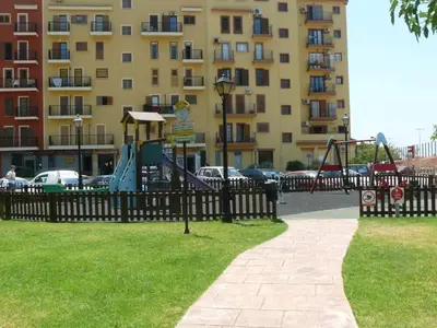 a playground in a park next to a building at ValenciaBeachHome in Port Saplaya