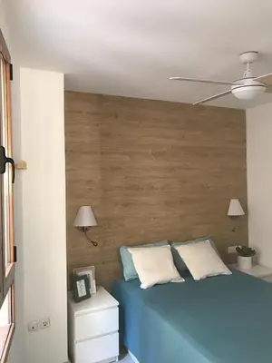 a bedroom with a blue bed with a wooden headboard at Apartamento Joseph , luminoso, bonito y muy céntrico in Valencia