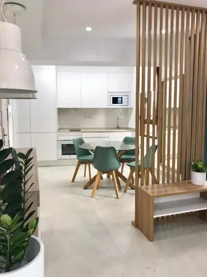 a kitchen with white cabinets and green chairs and a table at Apartamento Joseph , luminoso, bonito y muy céntrico in Valencia