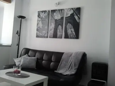 a living room with a black couch and a table at Carrer de Dénia in Valencia
