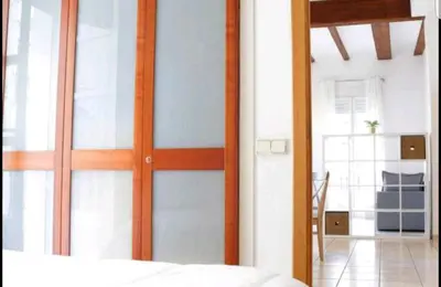 a bedroom with a sliding glass door with a bed at Junto al Mercado de Ruzafa in Valencia
