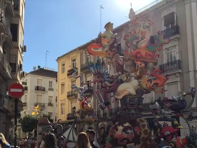 a crowd of people walking down a city street with a mural at Junto al Mercado de Ruzafa in Valencia
