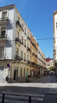 a large white building with balconies on a city street at Junto al Mercado de Ruzafa in Valencia