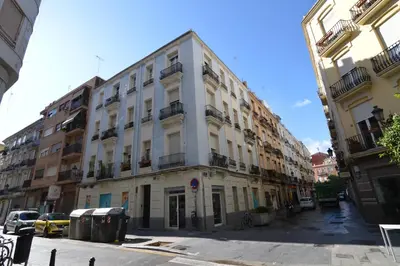 a large white building on a city street at Junto al Mercado de Ruzafa in Valencia