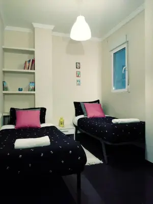 a living room with two beds and a couch at Habitaciones Centricas en una casa Valenciana in Valencia