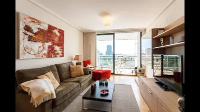 a living room with a couch and a large window at Apartamento en la Ciudad de las Ciencias y cerca de la playa in Valencia