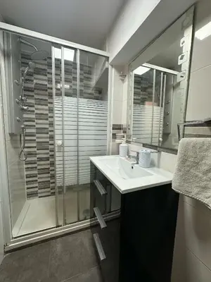 a bathroom with a glass shower and a sink at Apartamento Barbacoa, Piscina y playa in Puebla de Farnals