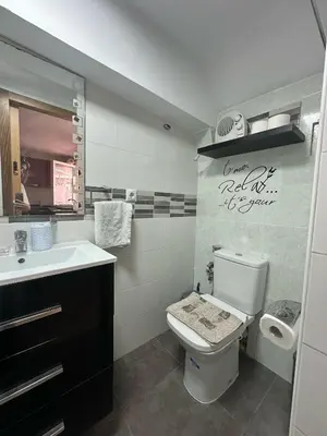 a bathroom with a toilet and a sink at Apartamento Barbacoa, Piscina y playa in Puebla de Farnals