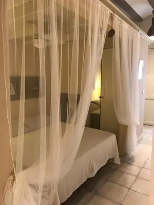 a bedroom with a bed with white curtains at Apartamento Romántico in Valencia