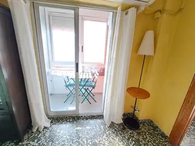 a room with a sliding glass door with a table at Full equipped and comfortable apartment with WiFi in Valencia