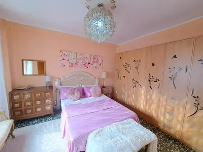 a bedroom with a pink bed and a chandelier at Full equipped and comfortable apartment with WiFi in Valencia