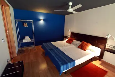 a bedroom with blue walls and a bed with orange pillows at Alojamiento ciudad las artes in Valencia