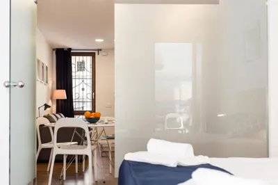 a bedroom with a bed and a table and chairs at Cabanyal Home in Valencia