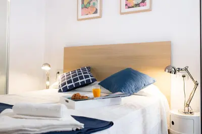 a bed with a tray of food and drinks on it at Cabanyal Home in Valencia