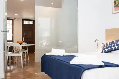 a bedroom with a bed with blue sheets and a table at Cabanyal Home in Valencia