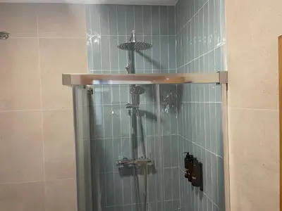 a shower in a bathroom with blue tiles at Cabanyal Home in Valencia