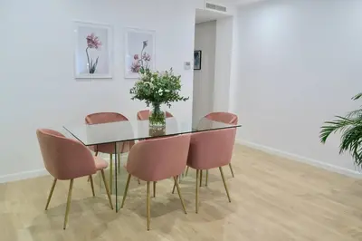a dining room table with pink chairs and a vase of flowers at Paz Velvet, Espectacular Piso en Calle La Paz in Valencia