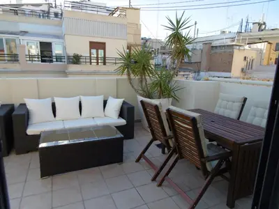 a balcony with a couch and a table and chairs at Ático Valencia Centro in Valencia