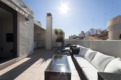 a balcony with a couch and a table on a building at Ático Valencia Centro in Valencia