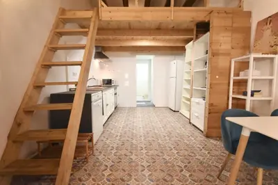 a kitchen with wooden stairs leading to a loft at Apartamento cerca de la playa in Valencia