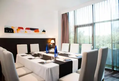 a dining room with a table and white chairs at Hotel Sercotel Plana Parc in Alquerías del Niño Perdido