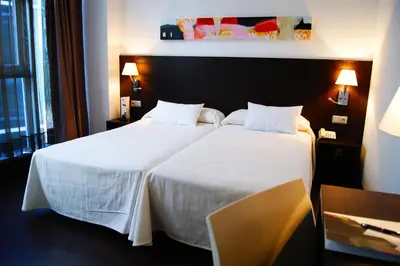 a hotel room with two beds with white sheets at Hotel Sercotel Plana Parc in Alquerías del Niño Perdido