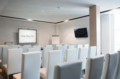 a conference room with white chairs and a screen at Hotel Sercotel Plana Parc in Alquerías del Niño Perdido