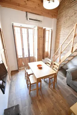 a living room with a wooden table and chairs at Apartamento en casa historica en la playa in Valencia