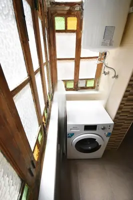 a washing machine in a small room with windows at Apartamento en casa historica en la playa in Valencia
