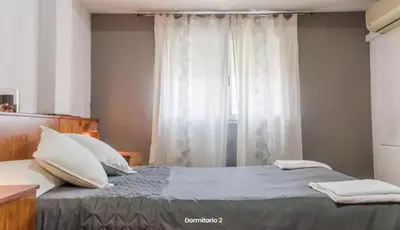 a bedroom with a bed with pillows and a window at AA la Nueva Fe in Valencia