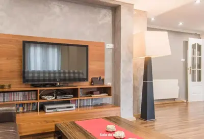 a living room with a television on a wooden entertainment center at AA la Nueva Fe in Valencia