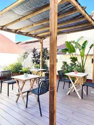 a wooden pergola with tables and chairs on a deck at Bird House in Valencia