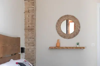 a mirror on a white wall with a shelf at Bird House in Valencia