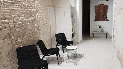 a room with three chairs and a table and a brick wall at PLAZA REDONDA brugada home in Valencia
