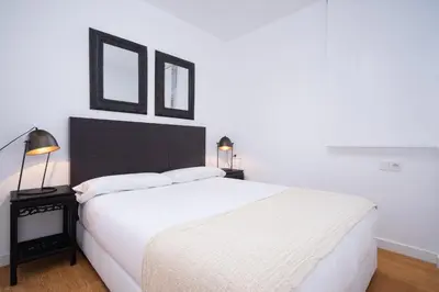 a bedroom with a large white bed and two pictures on the wall at Valencia Luxury - Boutique Market in Valencia