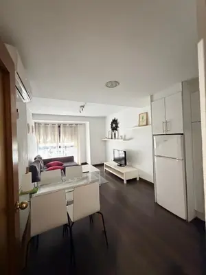 a kitchen and living room with a table and a refrigerator at Zerka Centro in Valencia