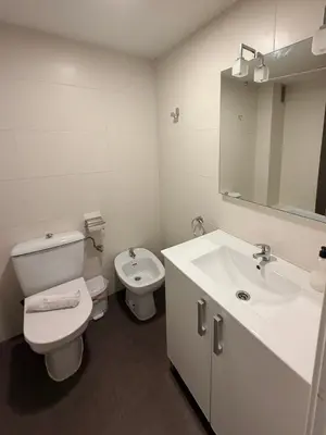 a white bathroom with a toilet and a sink at Zerka Centro in Valencia