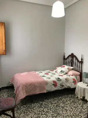 a bedroom with a bed and a table and a chair at Bonito piso en el centro de Benaguacil in Benaguacil