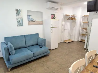 a living room with a blue couch and a table at Estudios en la playa in Valencia