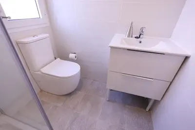 a white bathroom with a toilet and a sink at Apartamentos Dormavalencia in Valencia