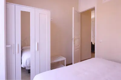 a white bedroom with a bed and a closet at Apartamentos Dormavalencia in Valencia