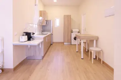 a kitchen with a sink and a table in a room at Apartamentos Dormavalencia in Valencia