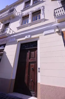 a white building with a wooden door on it at Apartamentos Dormavalencia in Valencia