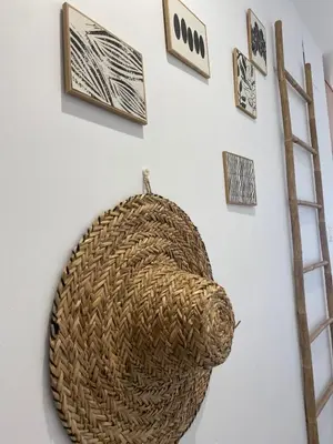 a basket hanging on a wall with pictures and a ladder at BEACH & SUN MONCOFA in Moncófar