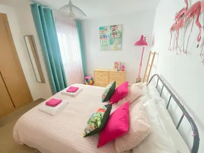 a bedroom with a bed with pink pillows on it at BEACH & SUN MONCOFA in Moncófar