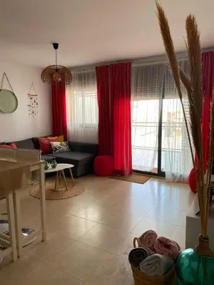 a living room with red curtains and a couch at BEACH & SUN MONCOFA in Moncófar