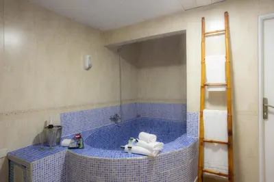 a bathroom with a blue tiled tub with a sink at Casual Civilizaciones Valencia in Valencia