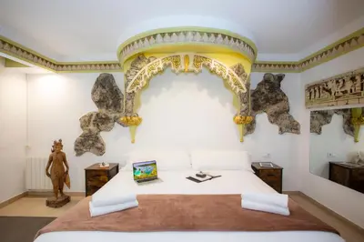 a bedroom with a white bed with an arch on the wall at Casual Civilizaciones Valencia in Valencia