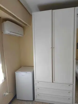 a closet with a refrigerator and a white cabinet at Se alquila una habitación doble con aire acondicionado in Valencia