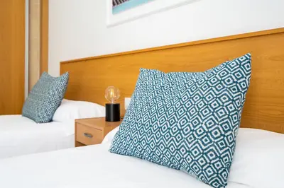 a bedroom with two beds with a blue and white pillow at Hostal RR Feria by Beleret in Valencia